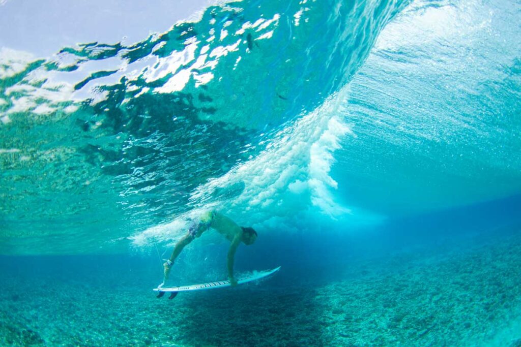 Surfista bajo una ola en Maldivas Sur, atolón de Huvadhoo.